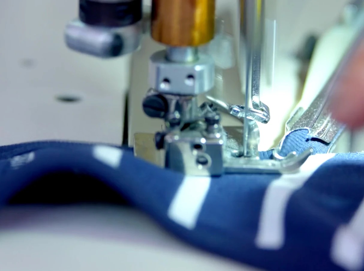 Gros plan sur la confection d'une pièce rayée à l'usine Petit Bateau de Troyes