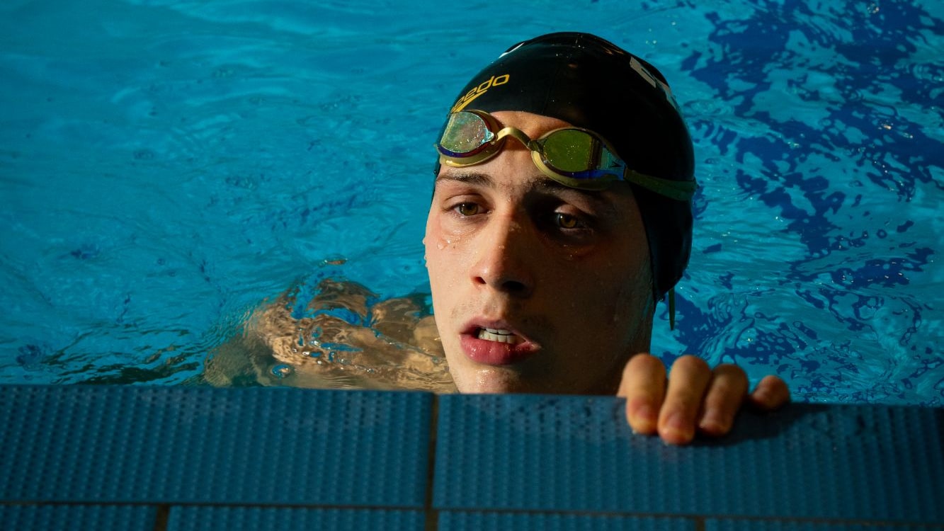 Nageur au bord du bassin, lunettes relevées sur le bonnet, pendant un entraînement de natation à l'Université Paris Nanterre